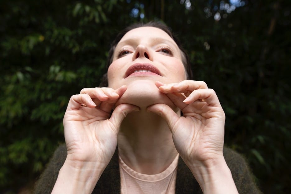 femme qui corrige le double menton avec le yoga du visage